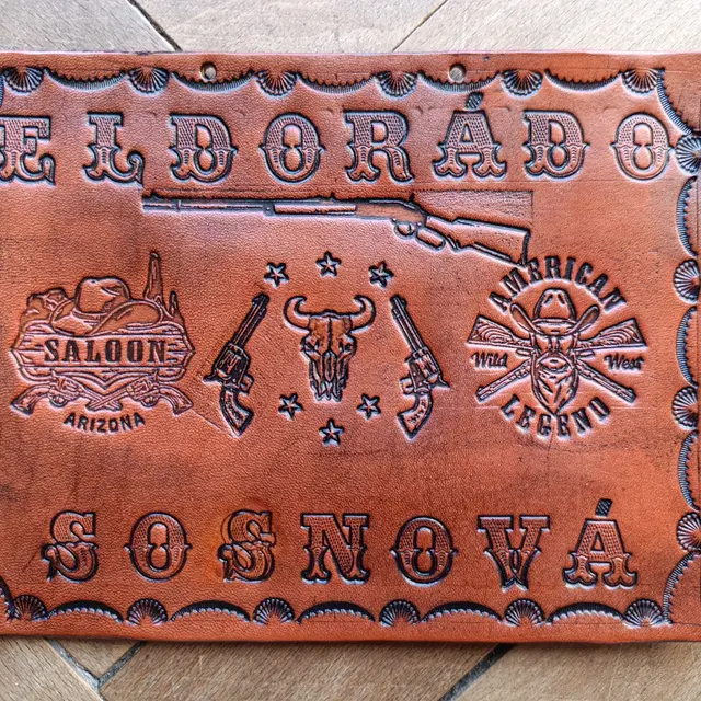 Detail ražené kožené cedule s dekorativními motivy.